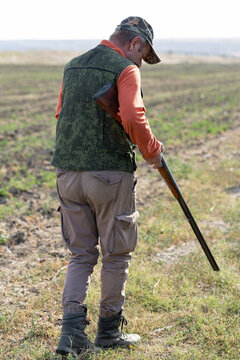 The hunter reloads his gun and prepares to shoot at game