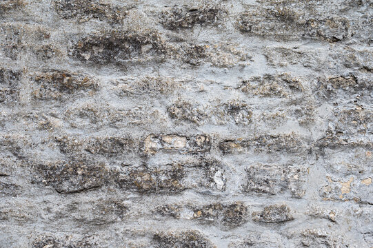 Weathered stone wall with rough cement texture