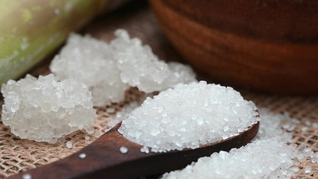 Fresh sugarcane stalks and raw sugar crystals representing India&rsquo;s sugar industry and the rising price of sugar in the Indian market. 