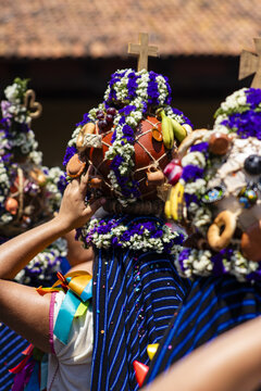 Uruapan, Michoacan, Mexico - 31 March 2024: View of Aguadoras carrying traditional clay pots decorated with flowers and fruit during a religious procession.