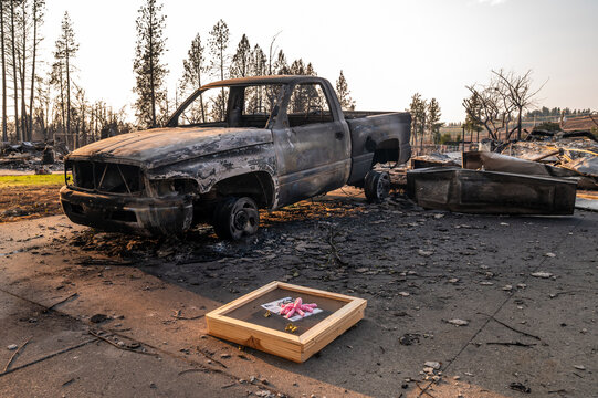 Spokane, Washington, United States - 14 August 2026: View of a fire-damaged neighborhood with sifting equipment and insurance company flyers left among wildfire debris.