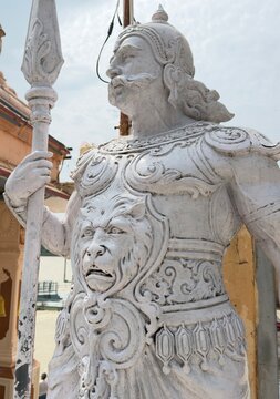  Stone sculpture of an ancient Indian warrior guard holding a spear outdoor