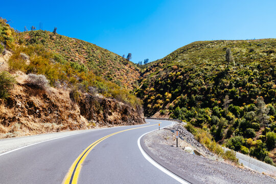 Winding mountain road in Mariposa County California through dry scrubland and forests
