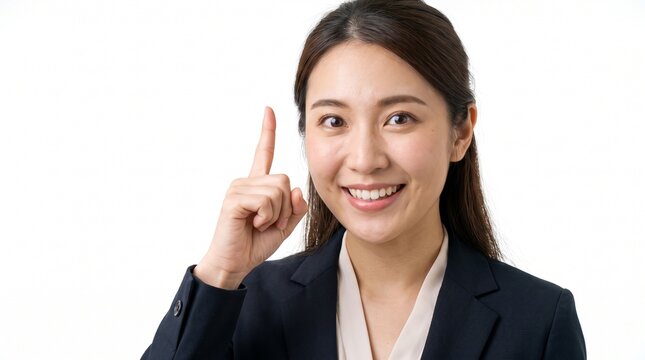Smiling Asian businesswoman pointing index finger up with brilliant idea