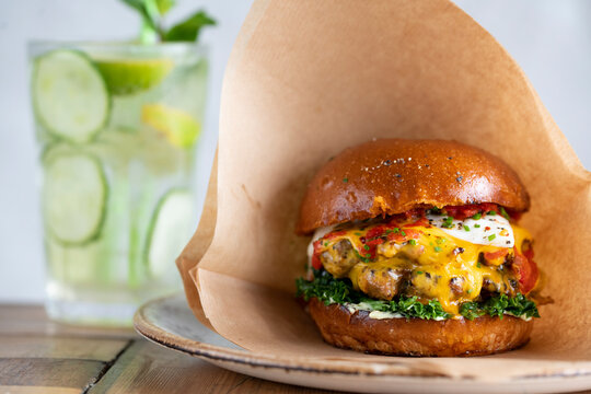 Delicious Burger With Fresh Toppings and Refreshing Drink in a Cozy Setting