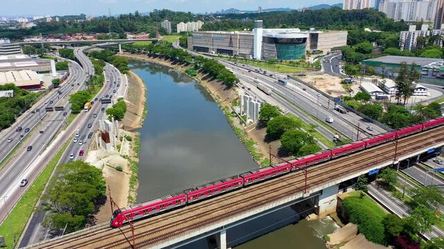 S&Atilde;O PAULO, BRASIL - 15 de AGOSTO de 2026: Vista a&eacute;rea de trem metropolitano da CPTM cruzando ponte sobre o Rio Tiet&ecirc; e pistas da Marginal Tiet&ecirc;