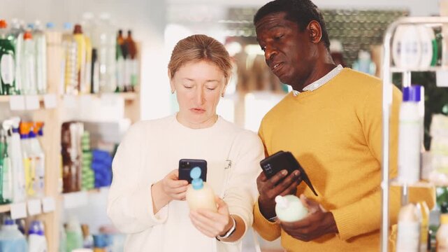 Couple adult man and adult woman buyers scanning qr code for liquid hand soap in household chemicals store