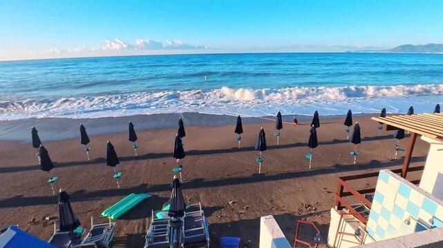 Elevated Coastal View Over a Mediterranean Beach With Waves and Blue Changing Huts, Borgio Verezzi, Italy - SIDE POV VIDEO - NO AUDIO