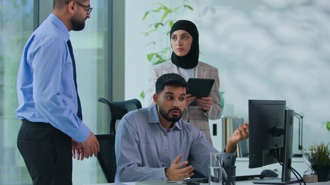 Arabian business team arguing in office Indian boss man dissatisfied talk to worker male in Indian leader angry talking to intern irritated with bad online laptop failure three Muslim agents argue