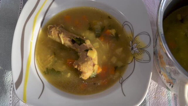 Chicken soup with vegetables in a dish. Homemade chicken soup close up. Chicken meat and vegetable. 