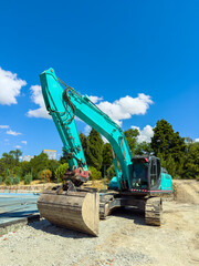Excavator working on a construction site under a clear blue sky in the afternoon © DSMT
