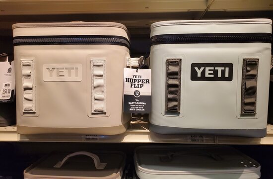 Atlantic City, New Jersey, U.S.A - Aug 16, 2026 - Beige and gray Yeti Hopper Flip 12 soft coolers displayed with tag describing tough construction and premium ice retention.