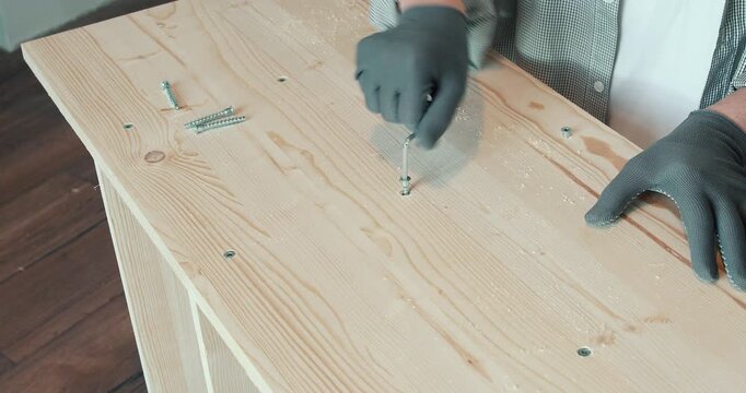 A man assembling a wooden bookshelf