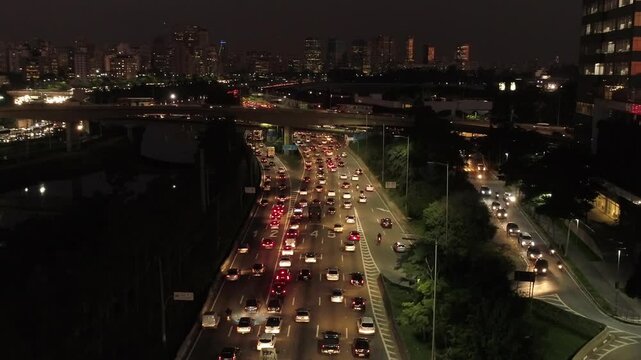 Vista A&eacute;rea Noturna de Drone da Marginal Pinheiros com Congestionamento, Viaduto e Skyline Iluminado em S&atilde;o Paulo