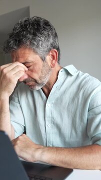 Stressed man feeling anxious at laptop suddenly relieved