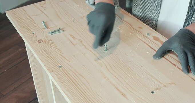 A man assembling a wooden bookshelf