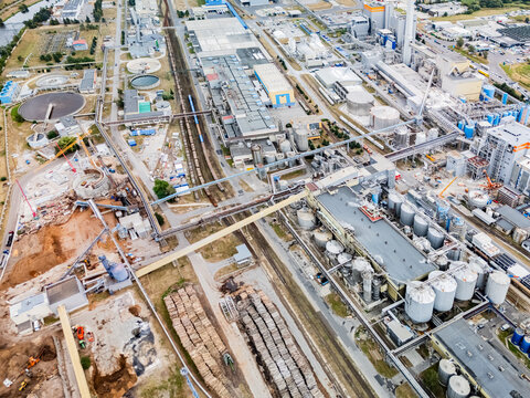 Aerial view of the Mondi SCP factory complex featuring industrial buildings, storage tanks, stacks of timber, and railway infrastructure in Ruzomberok, Zilinsky kraj, Slovakia.