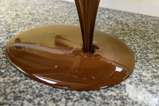 Le p&acirc;tissier &eacute;tale le chocolat encore chaud sur le marbre pour le travailler et le m&eacute;langer