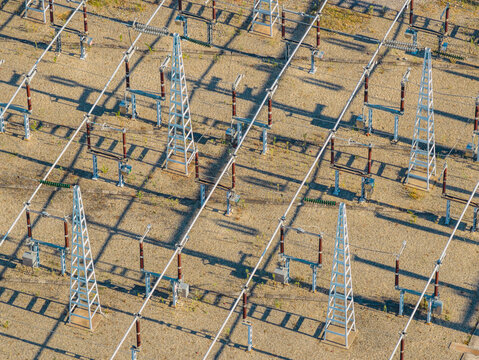 Aerial view of high voltage electrical switchgear, busbars, and insulators forming geometric patterns inside a power transmission substation in Saulce-sur-Rhone, Auvergne-Rhone-Alpes, France.