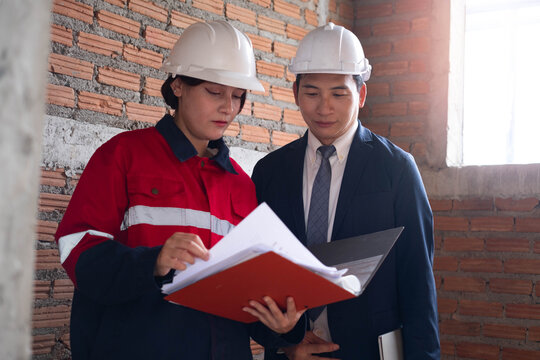 Construction professionals review building plans at an unfinished site, showing teamwork, engineering, architecture, project management, safety, collaboration, inspection, and construction planning.