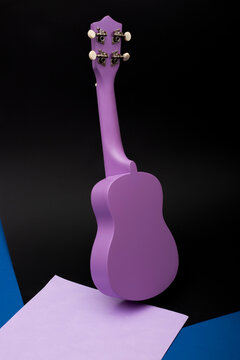 Four string ukulele guitar on black background