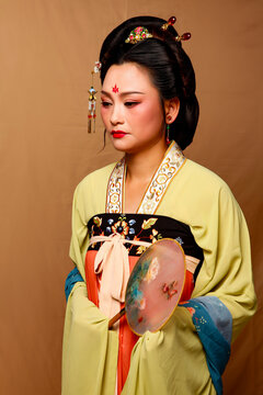Elegant East Asian Woman in Traditional Yellow Hanfu Studio Portrait