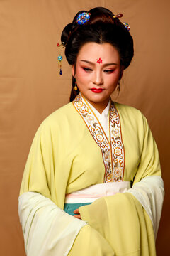 Elegant East Asian Woman in Traditional Yellow Hanfu Studio Portrait