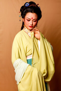 Elegant East Asian Woman in Traditional Yellow Hanfu Studio Portrait