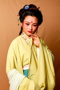 Elegant East Asian Woman in Traditional Yellow Hanfu Studio Portrait