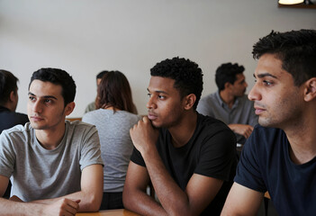 Obraz premium Diverse group of young men in a classroom setting, focused on learning and education, student life and academic environment
