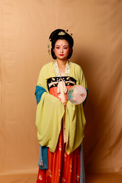 Elegant East Asian Woman in Traditional Yellow Hanfu Studio Portrait