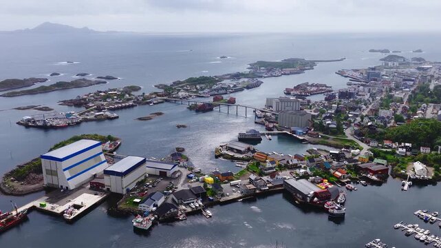 Aerial view of coastal town buildings, bridges, shipyards, and boats in the harbour of Svolvaer on the Lofoten archipelago in Norway.