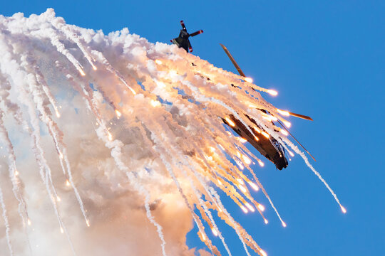 Military helicopter dropping flares during tactical maneuver