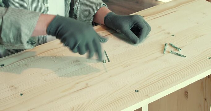 A man assembling a wooden bookshelf