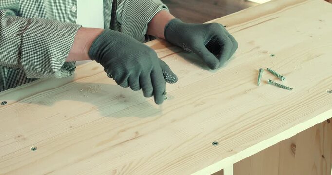 A man assembling a wooden bookshelf