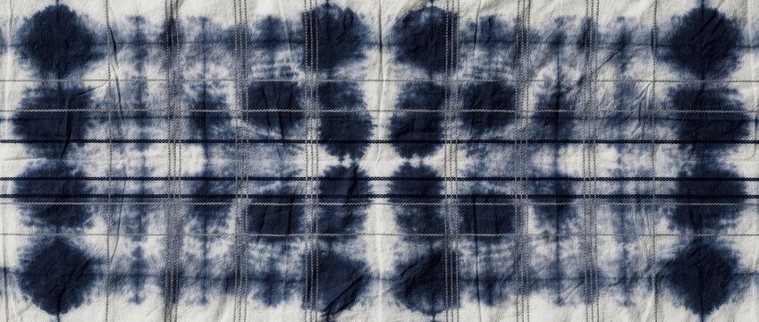 Blue indigo shibori tie-dye pattern on textured white fabric. Traditional Japanese hand-dyed textile with grid and circular motifs. Rustic bohemian aesthetic for interior and craft marketing.