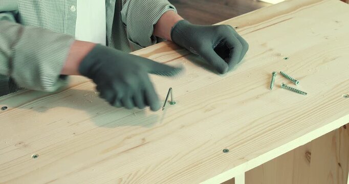 A man assembling a wooden bookshelf