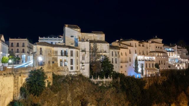Fotograf&iacute;a nocturna tradicionales casas blancas colgando sobre precipicio en la villa de Ronda, Andaluc&iacute;a, Espa&ntilde;a