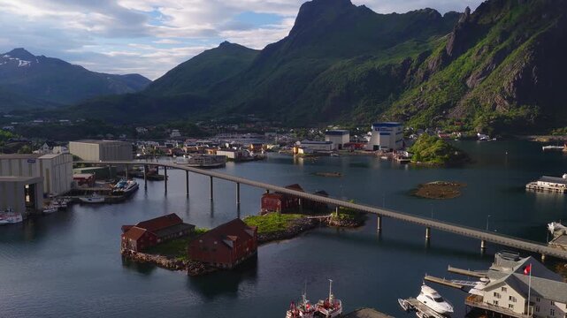 Aerial view over the harbor and bridge connecting islets in Svolvaer, Lofoten islands, Norway, surrounded by dramatic coastal mountains.