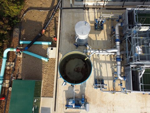 Aerial view of Raunds Water Recycling Centre showing industrial tanks, complex piping systems, and water treatment infrastructure in Raunds, England, United Kingdom.