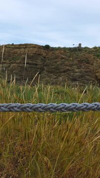 A thick rope serves as a barrier between the path and the gorge. vertical video