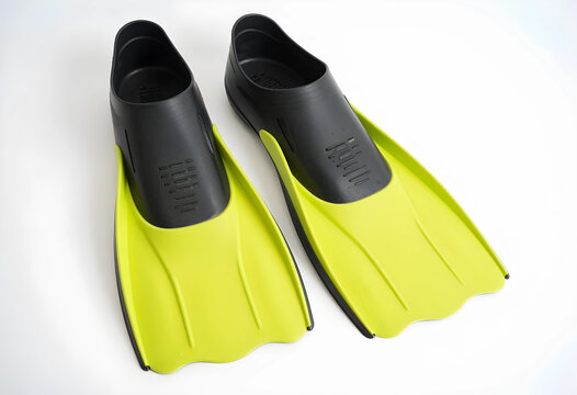 Swimming and snorkeling equipment, pair of bright yellow and black flippers for water sports and diving on white background