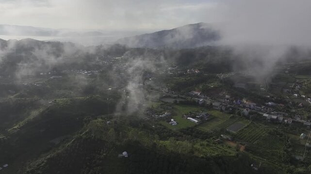 Aerial drone view of Don Duong Lake from Dran Pass, surrounded by green mountains and valleys in D'Ran, Lam Dong Province, Vietnam.