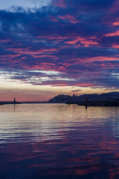 Clouds at sunset with cityscape silhouette, Imperia, Liguria region, Italy