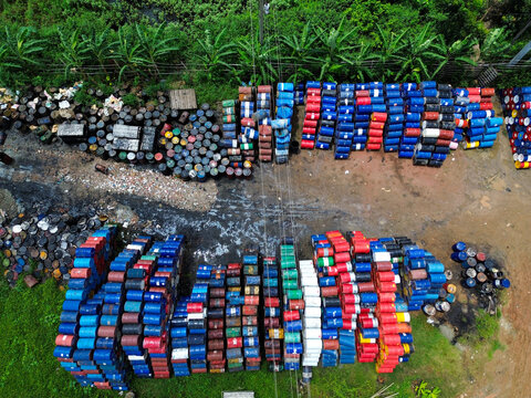 Aerial view of stacks of colorful industrial drums arranged in rows on a dirt yard in Dhaka, Dhaka Division, Bangladesh.