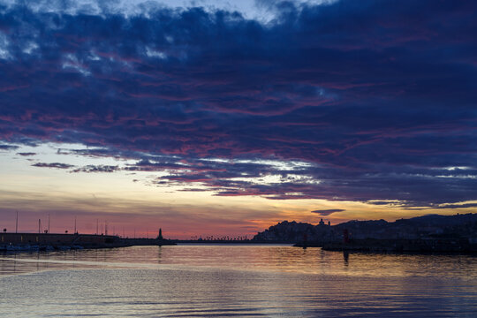 Clouds at sunset with cityscape silhouette, Imperia, Liguria region, Italy