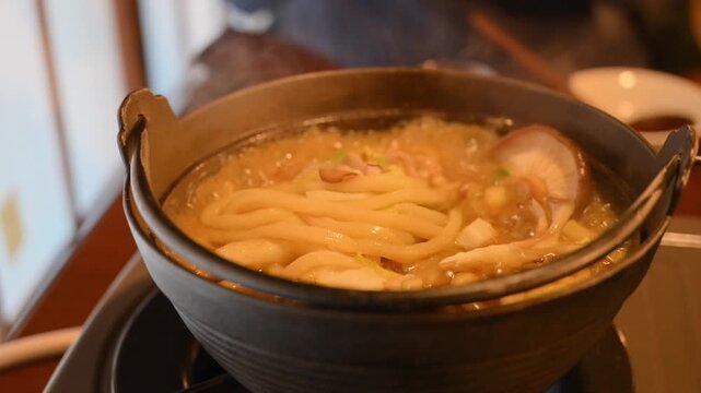 ガスコンロの点火とぐつぐつ煮える鍋焼きうどん