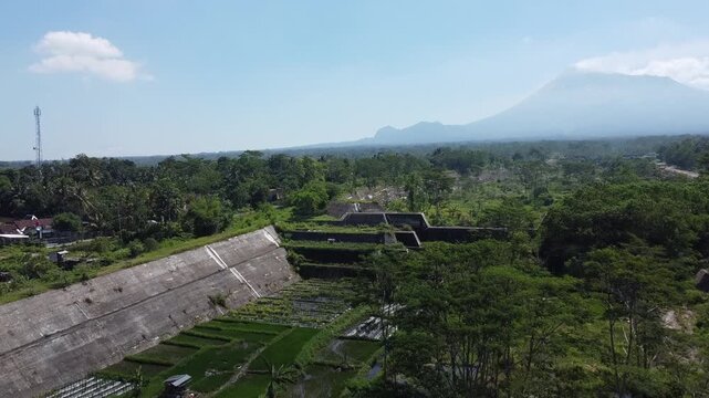 Aerial view of sabo dam and green rice fields with Mount Merapi background in daylight