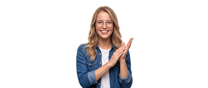 Smiling woman clapping hands in applause while wearing eyeglasses and denim shirt against a white studio background, expressing sincere appreciation, success, and positive approval