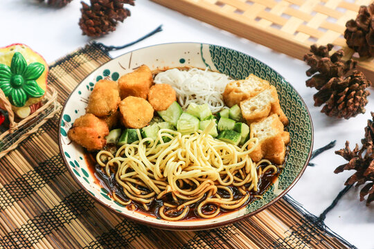 Rujak mie, a Palembang specialty, combines yellow egg noodles, fried tofu, pempek fish cakes, diced cucumber, rice vermicelli, and a tangy sweet-sour sauce called cuko.